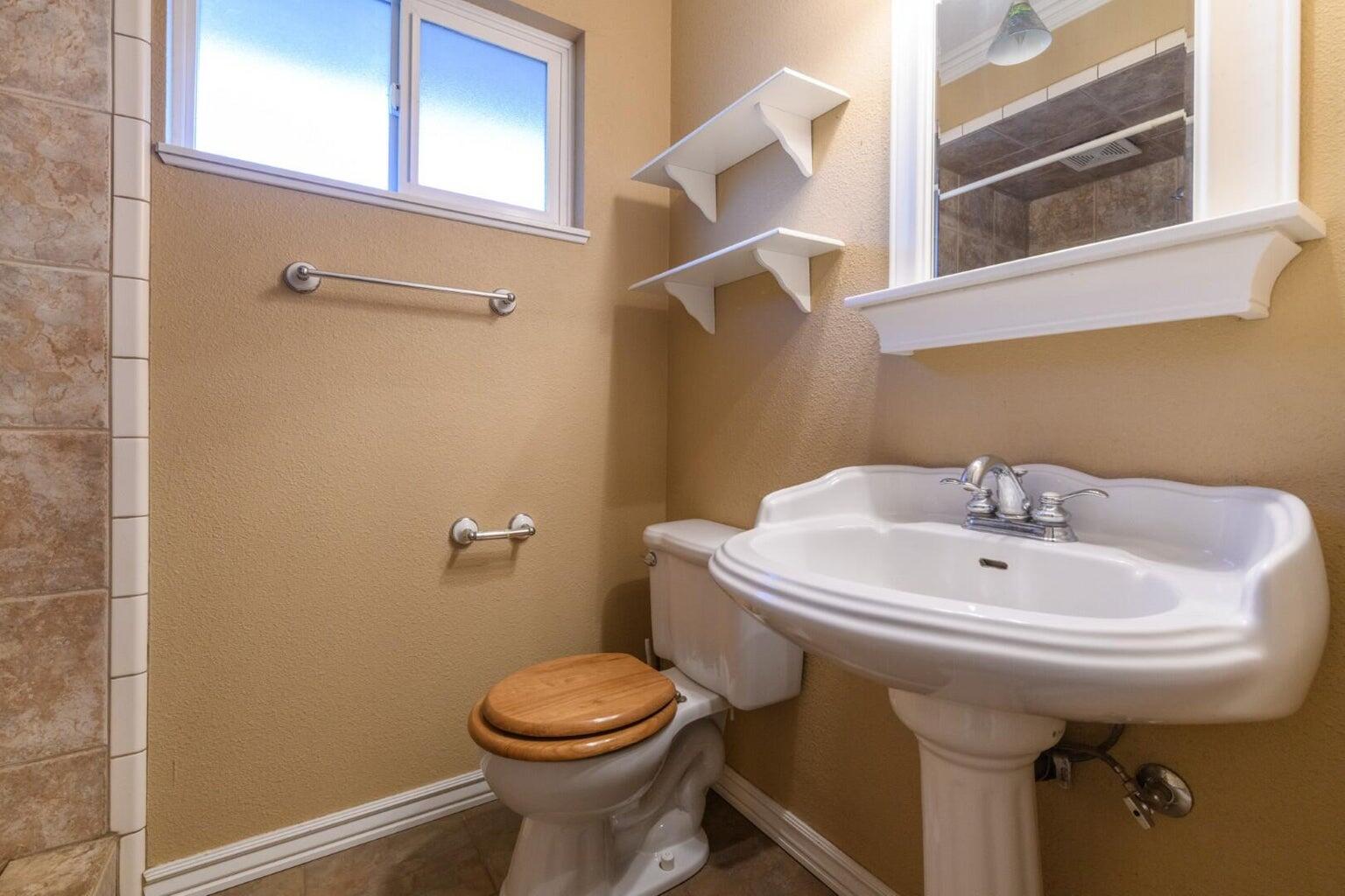 6781 Reflection Street Redding, CA 96001 - Photo 9 of 13 a bathroom with a sink a toilet and mirror