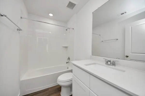 a bathroom with a granite countertop sink a toilet and shower