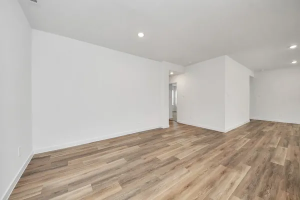a view of empty room with wooden floor