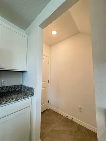 a bathroom with a granite countertop sink and white cabinets