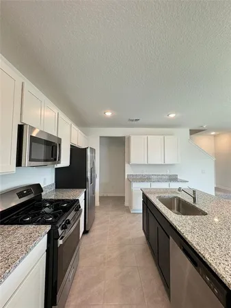 a kitchen with kitchen island granite countertop a sink window and cabinets