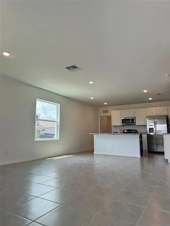 a large kitchen with a large counter top stainless steel appliances and cabinets