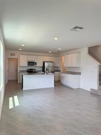 a large kitchen with a refrigerator and a stove top oven
