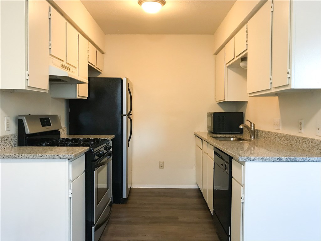 a kitchen with stainless steel appliances granite countertop a stove a sink and a microwave