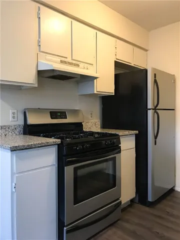 a kitchen with stainless steel appliances granite countertop a stove a refrigerator and a microwave