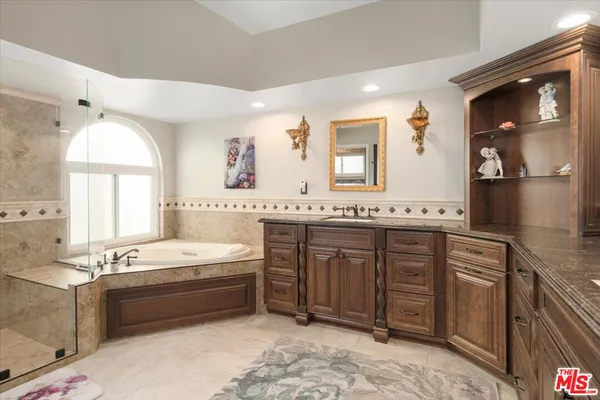 a bathroom with a granite countertop sink double vanity and a mirror