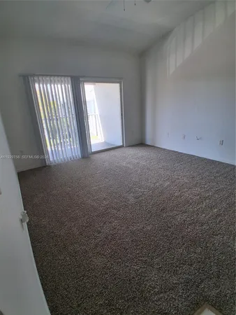 a view of a livingroom with an empty space and a window