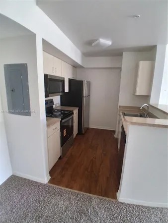 a kitchen with a refrigerator and a sink