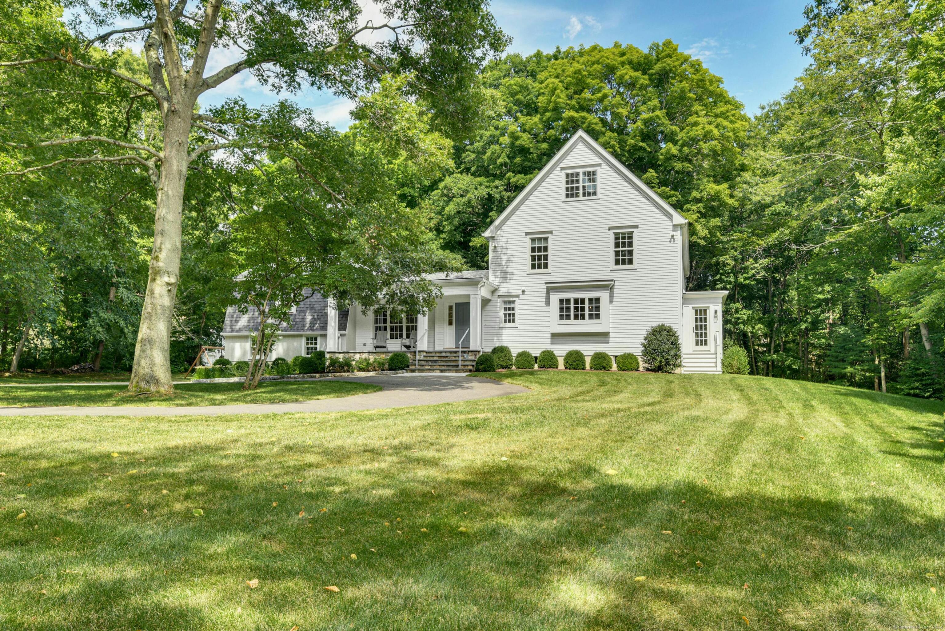 a front view of a house with a yard and trees