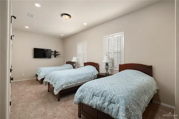 a bedroom with two beds and a flat screen tv