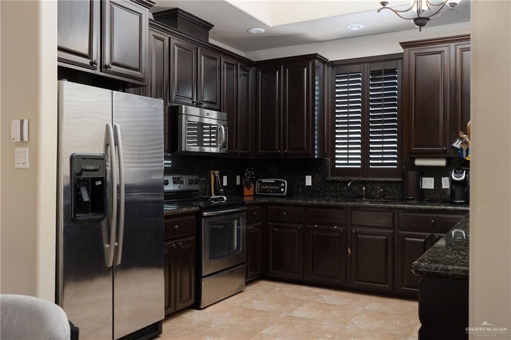 605 Ithaca Avenue McAllen, TX 78501 - Photo 7 of 23 a kitchen with stainless steel appliances granite countertop a refrigerator and a stove