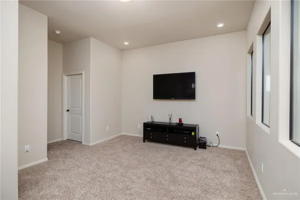 a living room with flat screen tv and a refrigerator