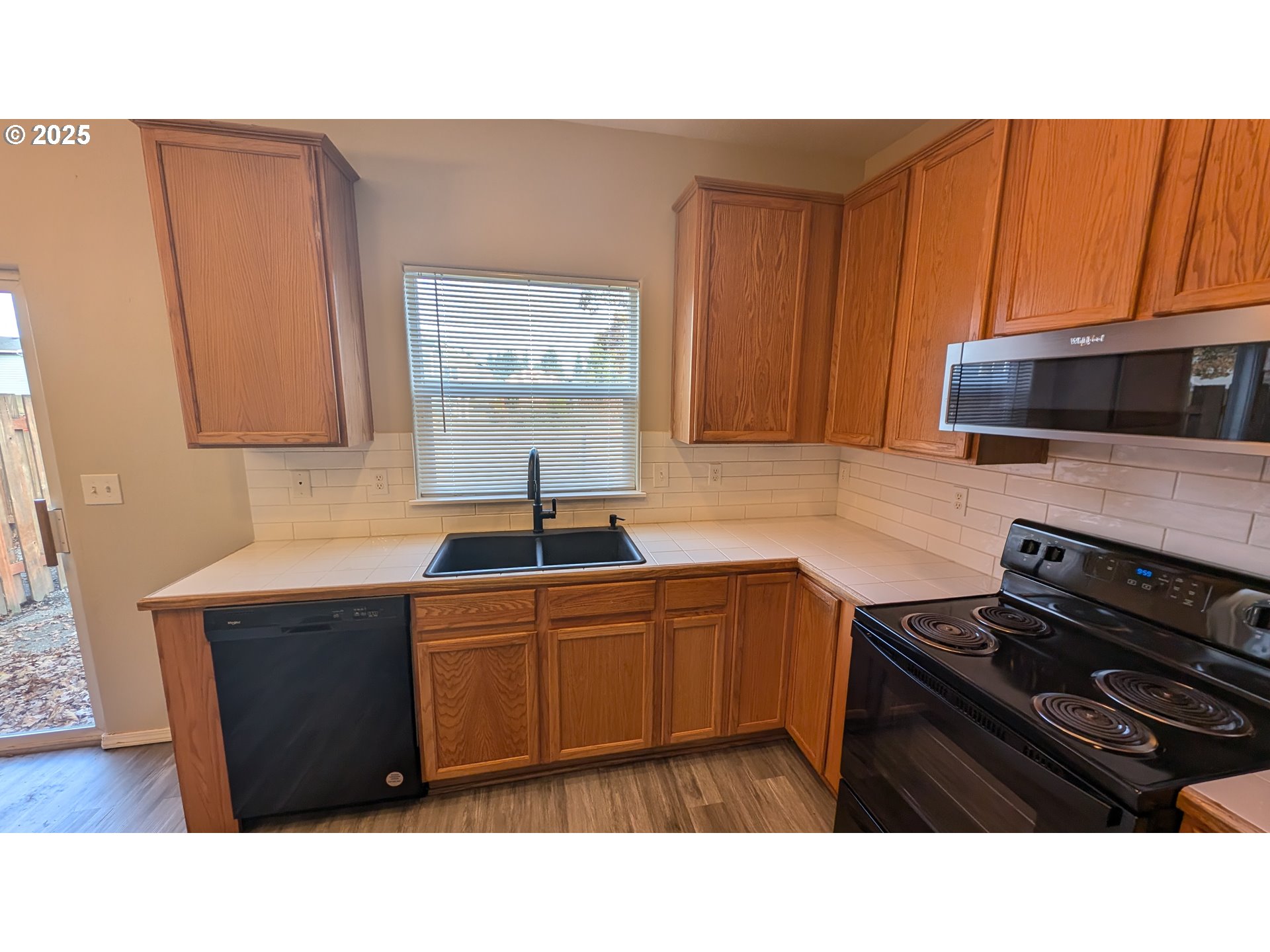 18541 Southwest Takena Court Beaverton, OR 97003 - Photo 11 of 24 a kitchen with a sink a stove and cabinets