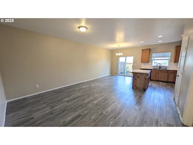 a open kitchen with cabinets and wooden floor