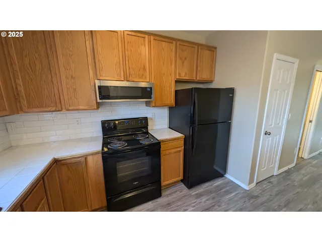 a kitchen with a refrigerator stove and cabinets