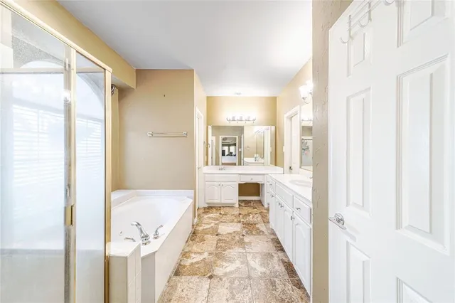 a bathroom with a tub sink and mirror