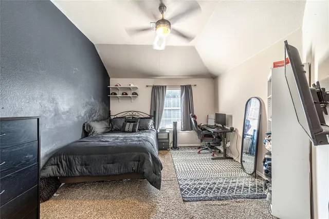 a bedroom with a bed a chandelier and dresser