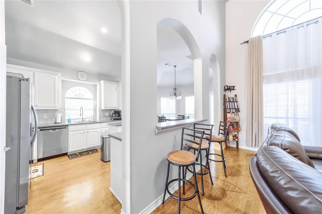 8001 St Fillans Lane Rowlett, TX 75089 - Photo 2 of 40 a kitchen with stainless steel appliances kitchen island granite countertop a table and chairs in it