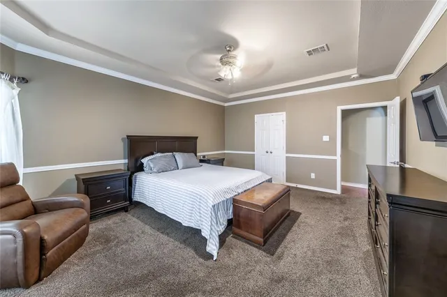 a bedroom with a bed couch and a view of living room