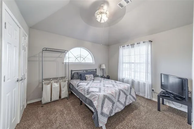 a bedroom with a bed and a large window