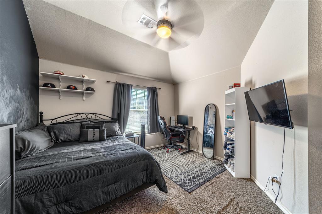 8001 St Fillans Lane Rowlett, TX 75089 - Photo 28 of 40 a bedroom with a bed and a flat tv screen on the dresser