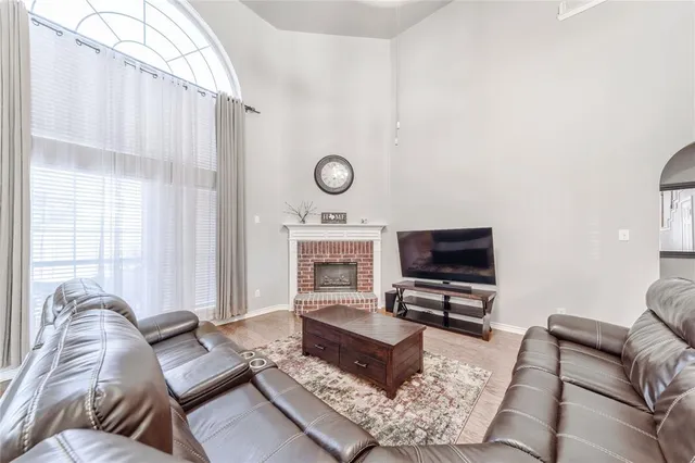 a living room with furniture a flat screen tv and a window