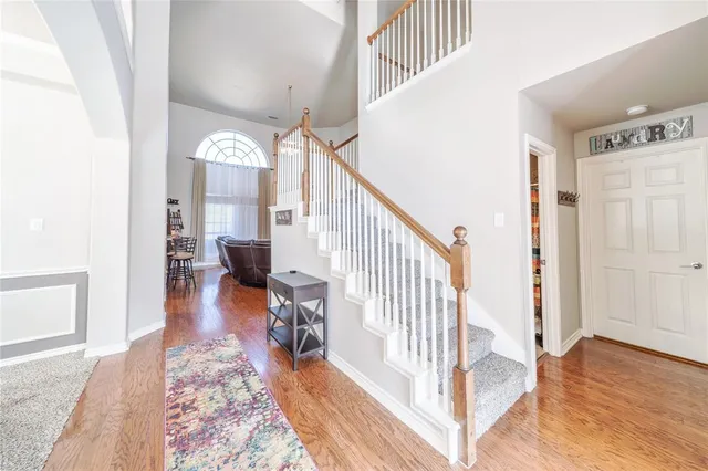 a view of a hallway with wooden floor and stairs