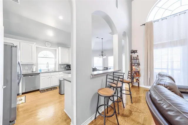 a kitchen with stainless steel appliances kitchen island granite countertop a table and chairs in it