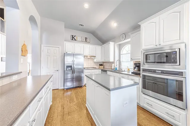 a kitchen with granite countertop a sink stove and refrigerator