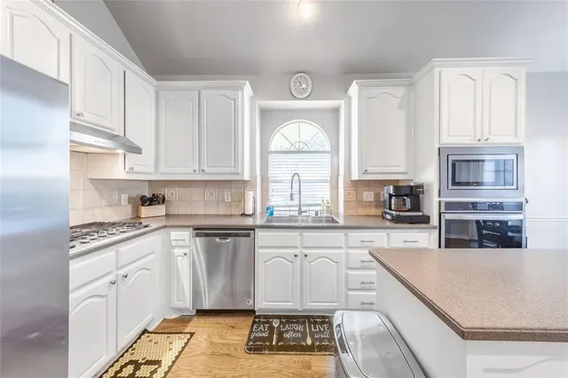 a large kitchen with cabinets appliances and a counter space