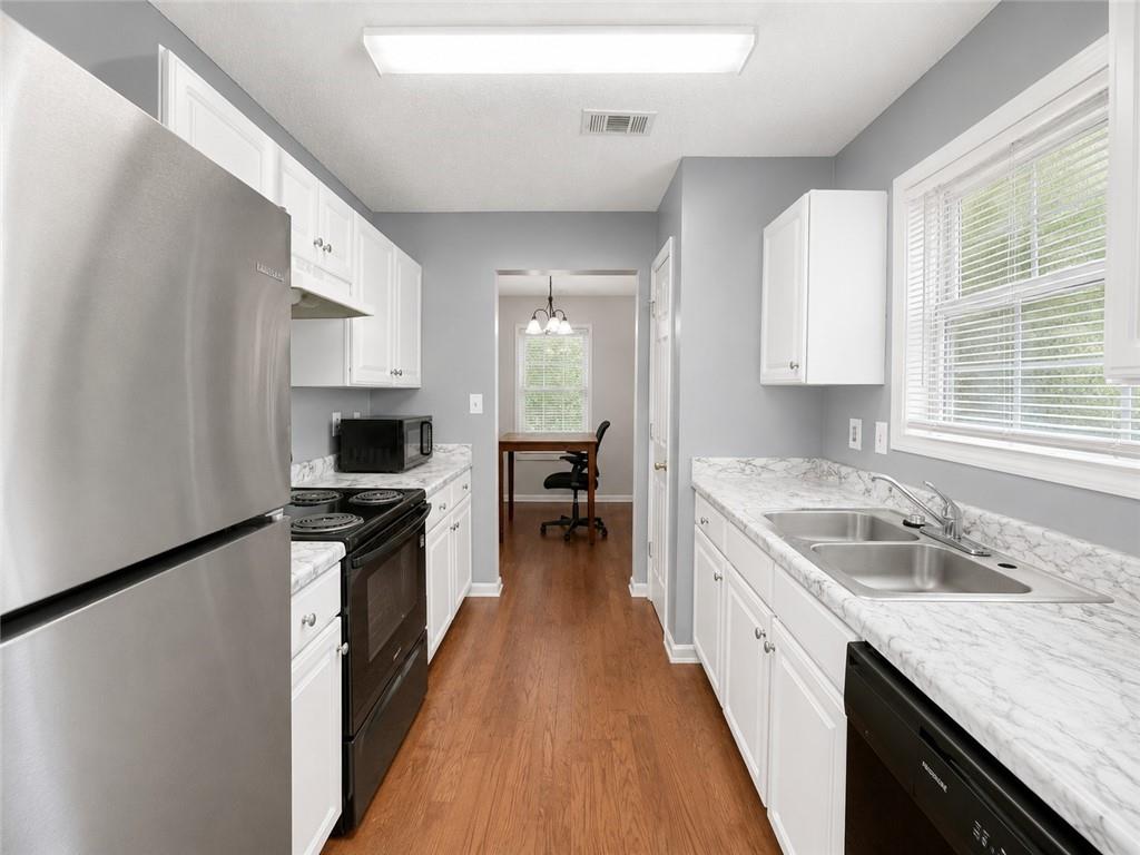 6936 Red Bone Way Stonecrest, GA 30038 - Photo 5 of 17 a large kitchen with a stove top oven a sink a counter space and cabinets