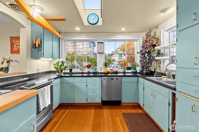 a view of a hallway with wooden floor and a bathroom