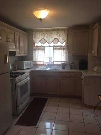 941 Middle Street Fall River, MA 02724 - Photo 8 of 12 a kitchen with a sink a stove cabinets and a window