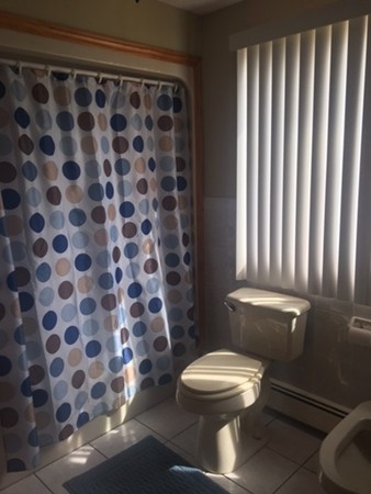 941 Middle Street Fall River, MA 02724 - Photo 10 of 12 a white toilet sitting next to a shower curtain