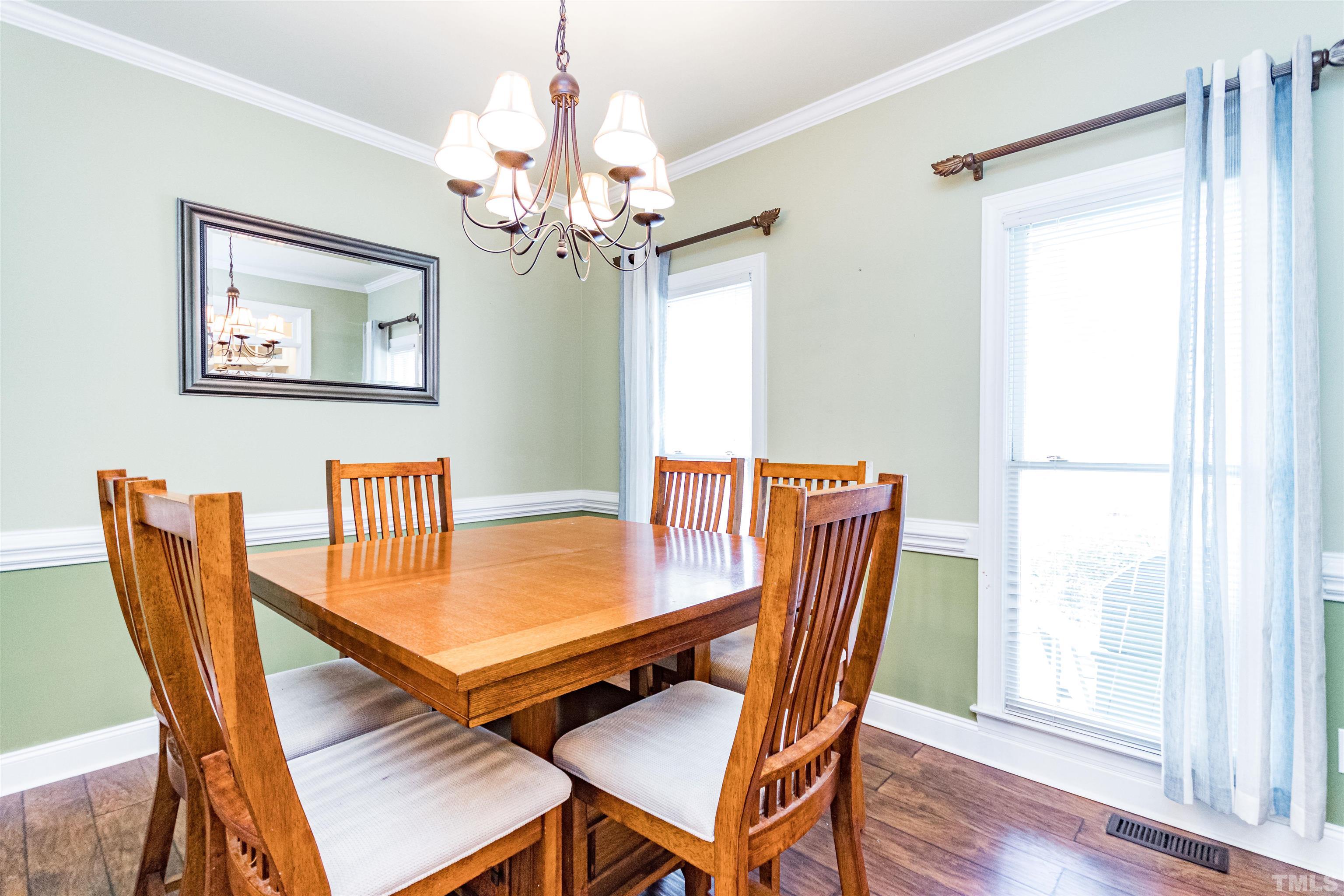 120 Kelsey Court Clayton, NC 27520 - Photo 13 of 62 a dining room with furniture a chandelier and wooden floor