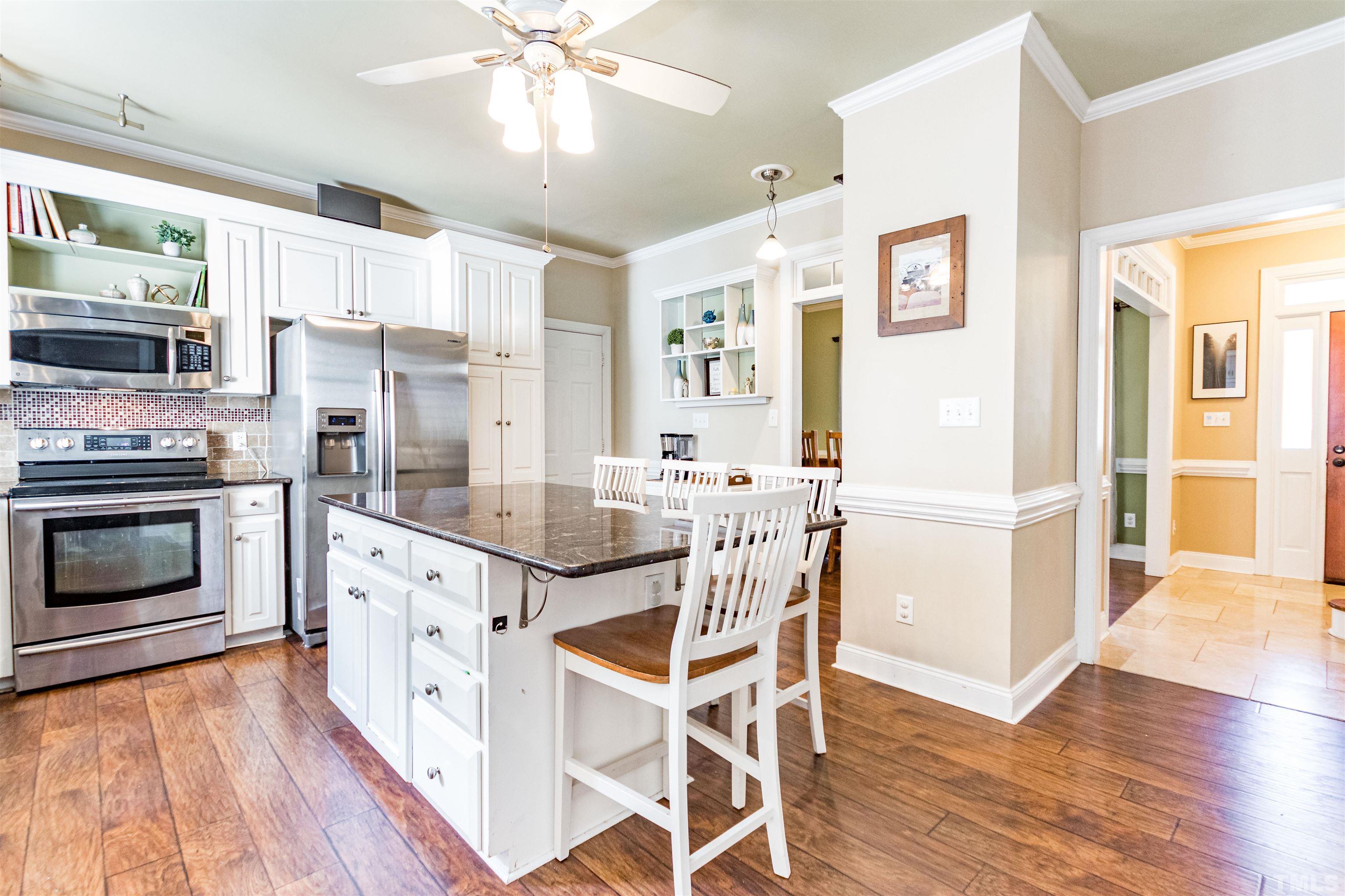 120 Kelsey Court Clayton, NC 27520 - Photo 17 of 62 a kitchen with stainless steel appliances kitchen island granite countertop a refrigerator and a stove top oven