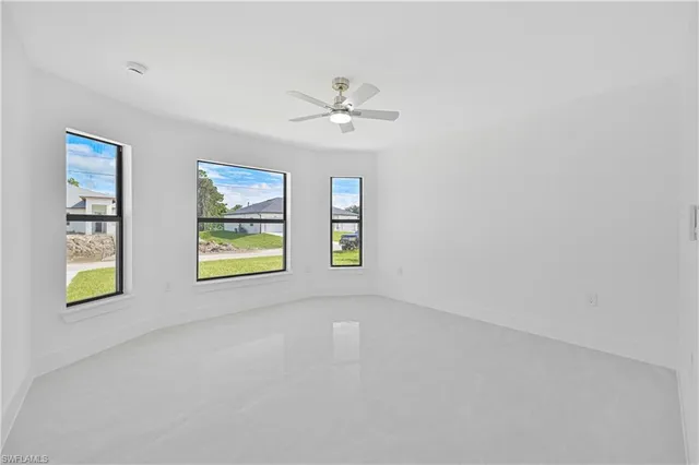 an empty room with windows and fan