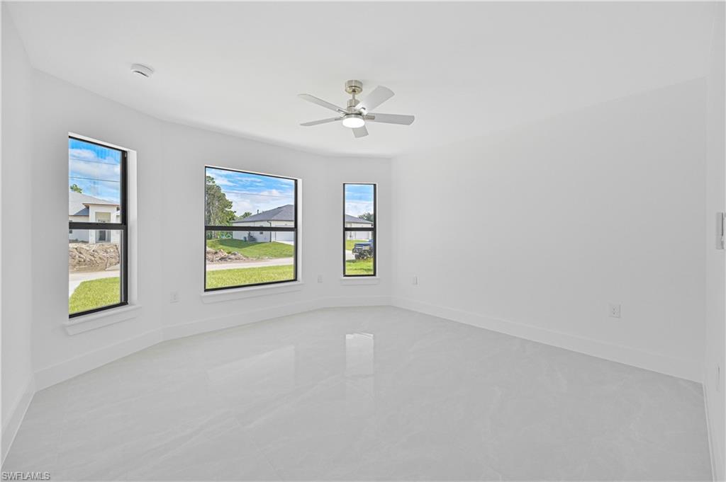 4709-4711 27th Street Southwest Lehigh Acres, FL 33973 - Photo 12 of 21 Spare room featuring a ceiling fan and baseboards