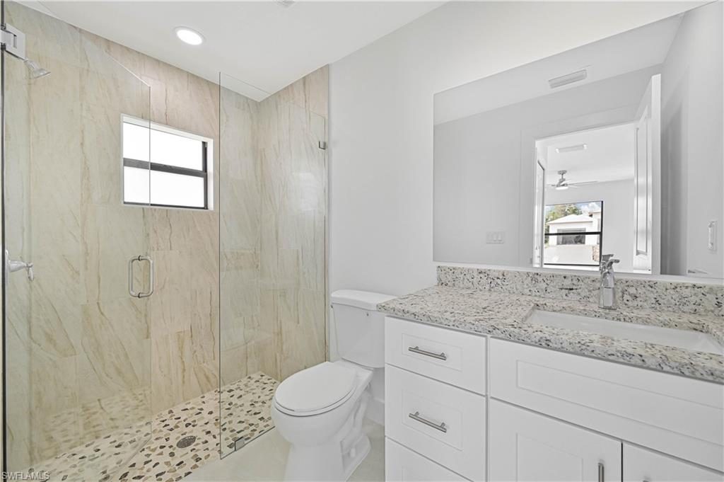 4709-4711 27th Street Southwest Lehigh Acres, FL 33973 - Photo 14 of 21 Bathroom with plenty of natural light, a marble finish shower, vanity, recessed lighting, and a ceiling fan