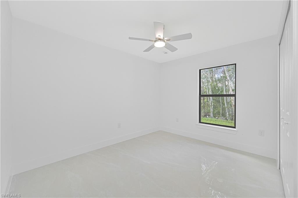 4709-4711 27th Street Southwest Lehigh Acres, FL 33973 - Photo 15 of 21 Spare room featuring a ceiling fan and baseboards