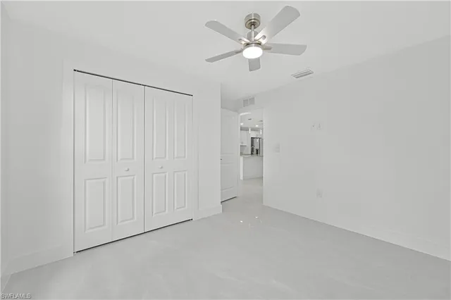 an empty room with a ceiling fan and a window