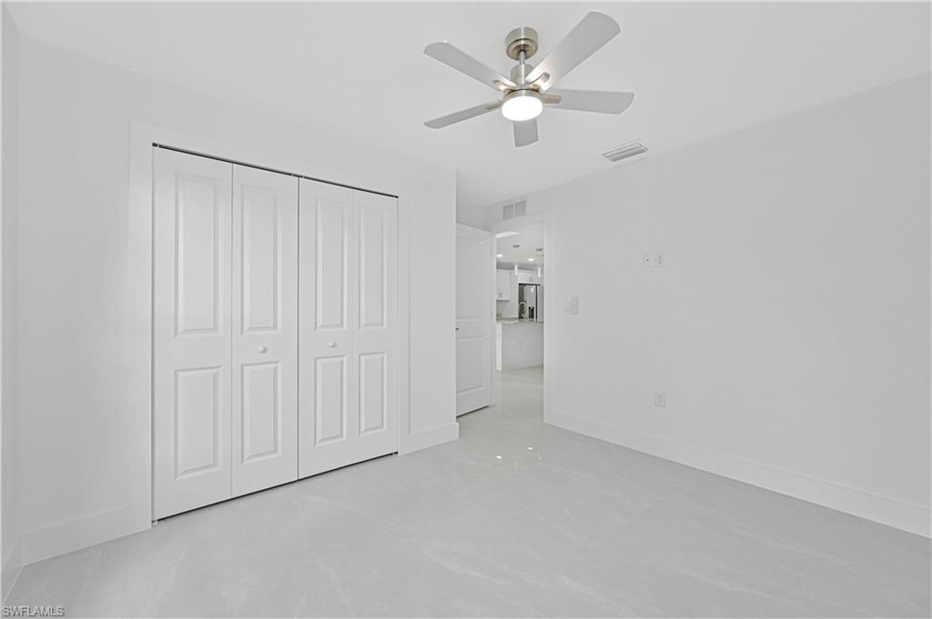 4709-4711 27th Street Southwest Lehigh Acres, FL 33973 - Photo 16 of 21 Unfurnished bedroom with a ceiling fan, a closet, and stainless steel fridge with ice dispenser