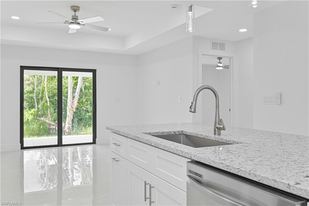 4709-4711 27th Street Southwest Lehigh Acres, FL 33973 - Photo 20 of 21 Kitchen featuring ceiling fan, light stone counters, dishwasher, recessed lighting, and white cabinets