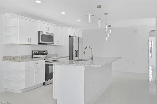 a kitchen with stainless steel appliances granite countertop a sink and cabinets
