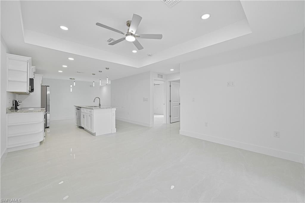 4709-4711 27th Street Southwest Lehigh Acres, FL 33973 - Photo 10 of 21 Unfurnished living room with recessed lighting, a tray ceiling, and a ceiling fan