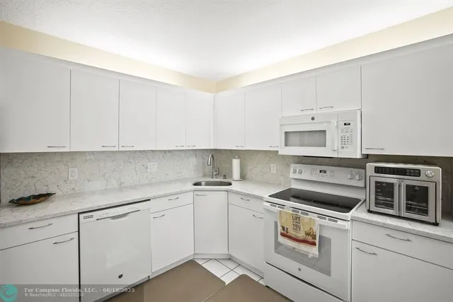 a kitchen with cabinets appliances and a sink