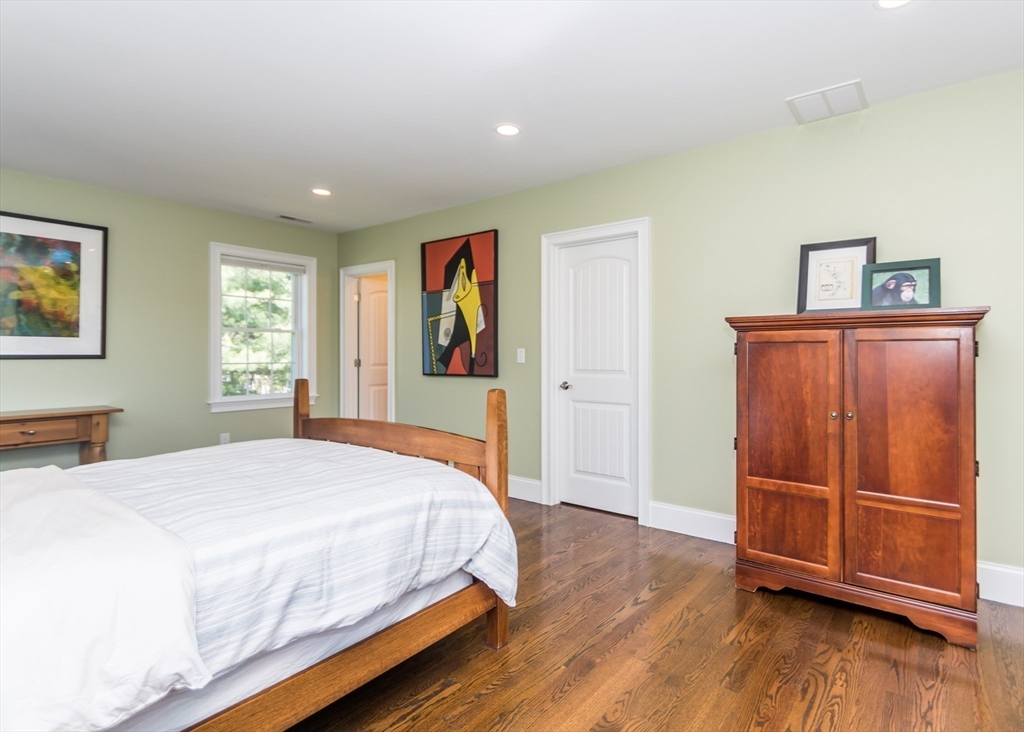 128 Church Street, Unit 2 Waltham, MA 02452 - Photo 29 of 41 a spacious bedroom with a bed and wooden floor