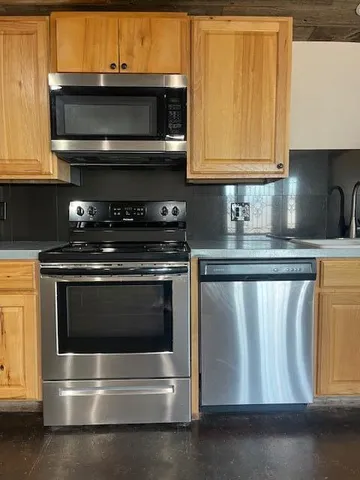 a kitchen with granite countertop a stove and a microwave