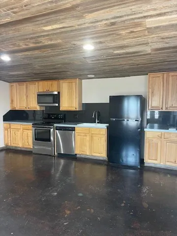 a kitchen with stainless steel appliances a refrigerator and a stove
