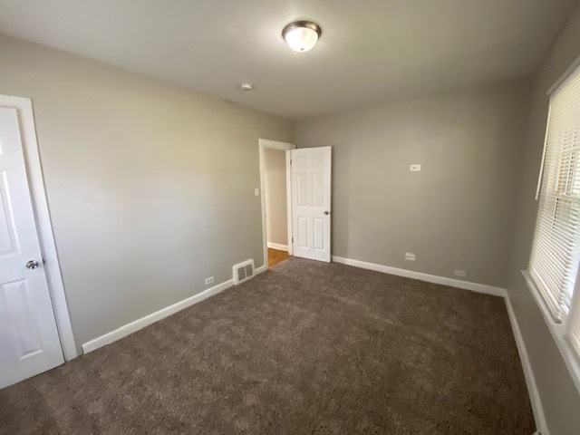 17843 Roy Street Lansing, IL 60438 - Photo 12 of 19 an empty room with windows and entrance